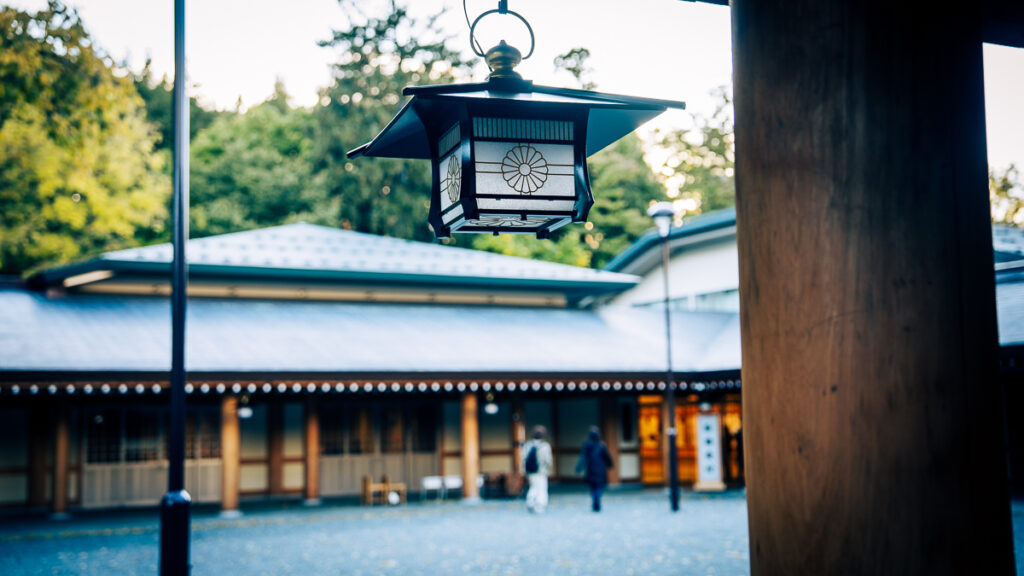 Lantern decorated with the imperial crest hanging above the gravel courtyard at Hokkaido-Jingu