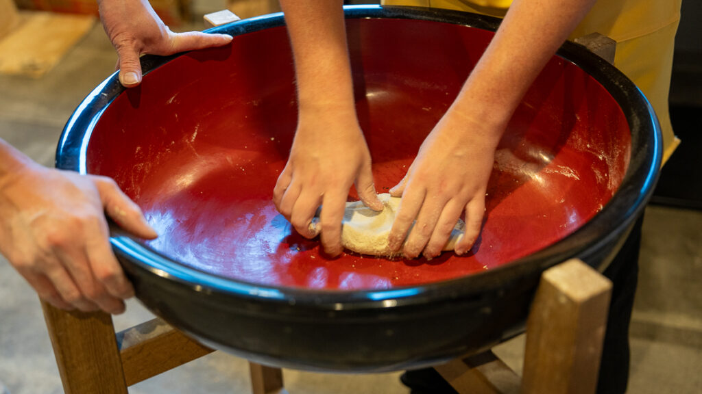 Close-up of hands kneading soba dough to a smooth texture in Sapporo, Hokkaido.
