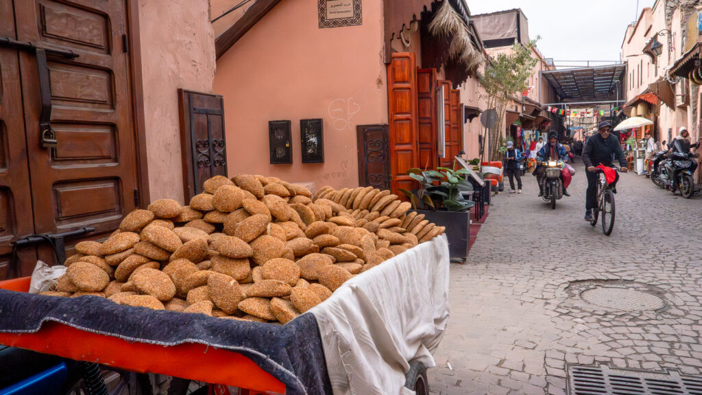 Wooden cart stacked with khobz bread on a busy Marrakech street