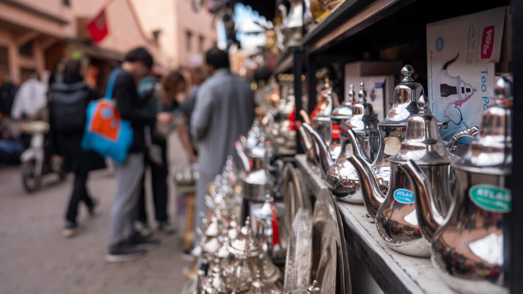 Traditional silver Moroccan teapots displayed in a souk shop.