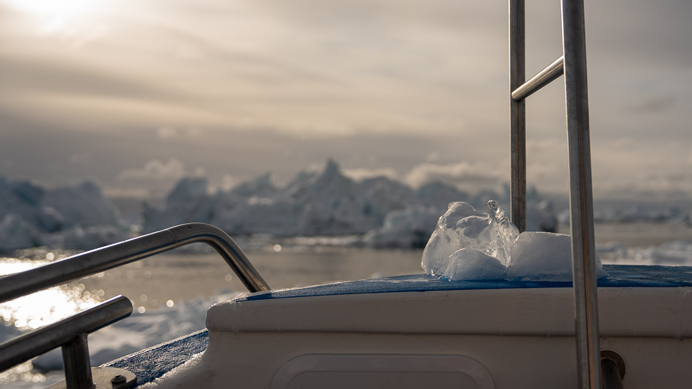 Piece of clear black ice resting on the bow of a tour boat in Disko Bay, Greenland.