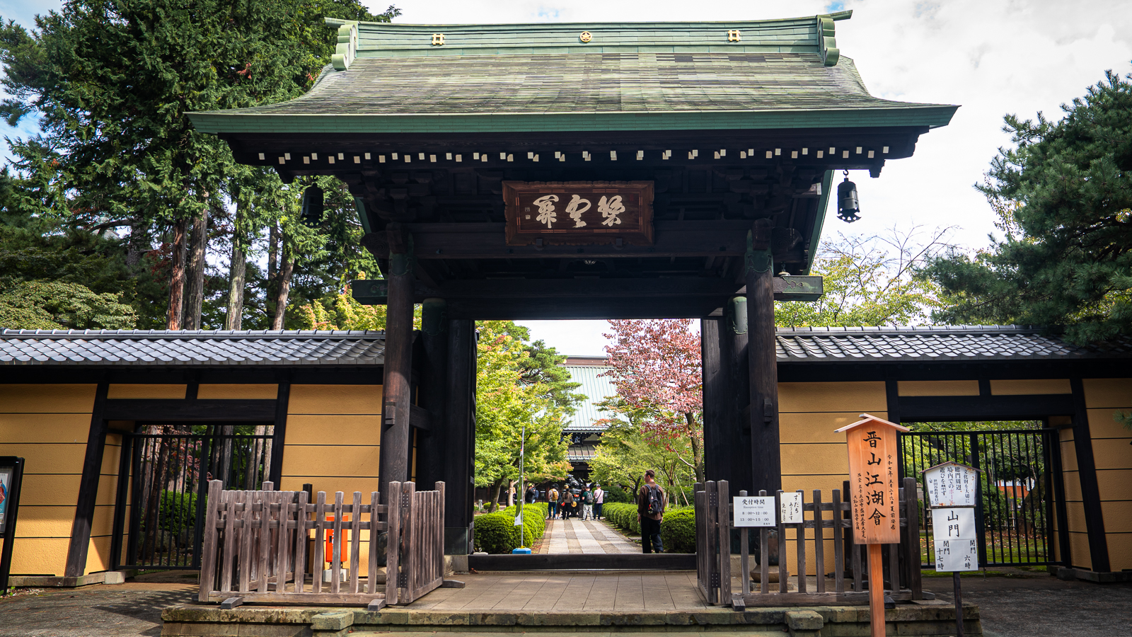 Main entrance gate to Gotokuji Temple with green tiled roof and wooden pillars, known as Hekiunkan Hall of Blue Clouds.