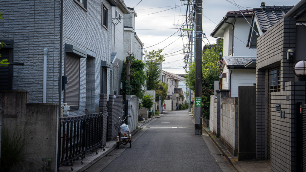 Quiet residential street near Gotokuji Temple in Setagaya, Tokyo, with a single bicycle and no people present.