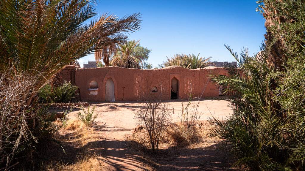 Guest rooms at Auberge Kasbah Touareg in M’Hamid, Morocco, arranged around an open courtyard area.
