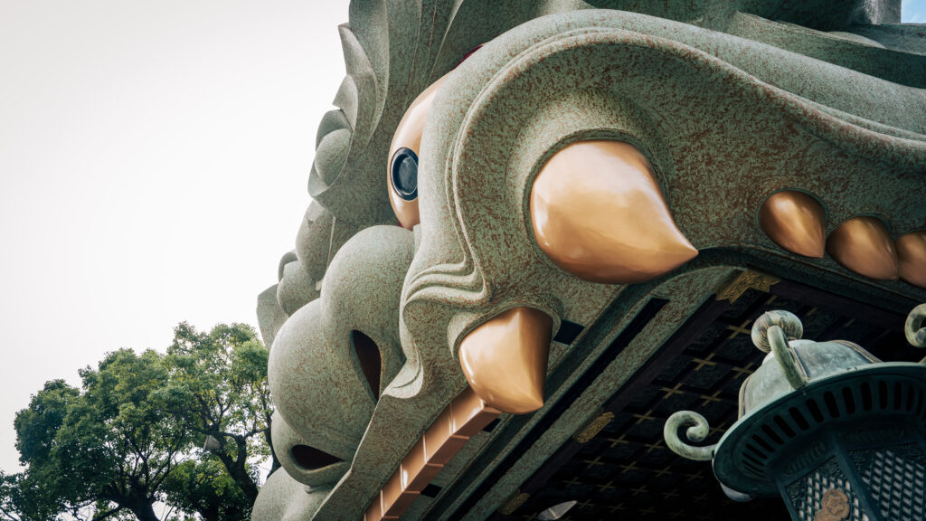 Upward view of the lion’s fangs at Namba Yasaka Shrine, emphasizing height and drama.