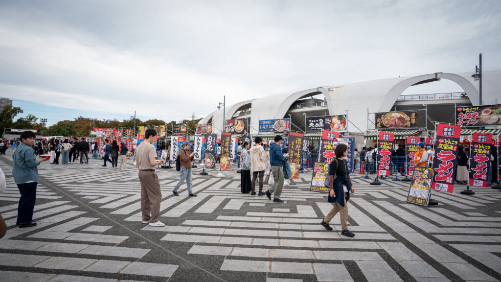 Visitors stroll past a long row of ramen booths at Tokyo Ramen Festa.