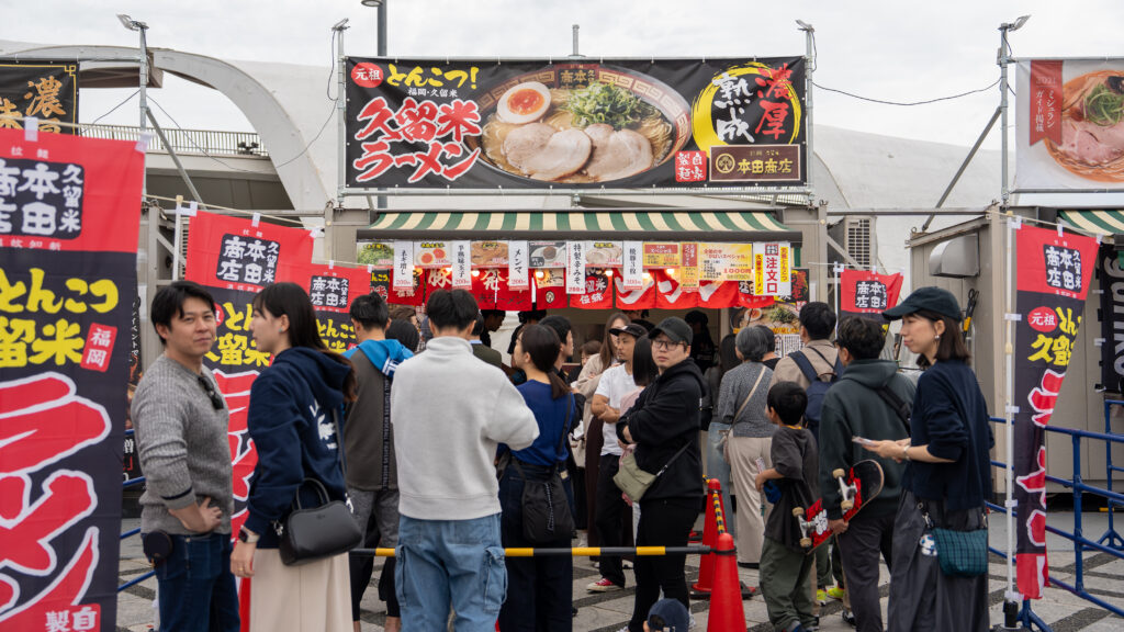 Large crowd waits outside a booth serving Kurume tonkatsu ramen.