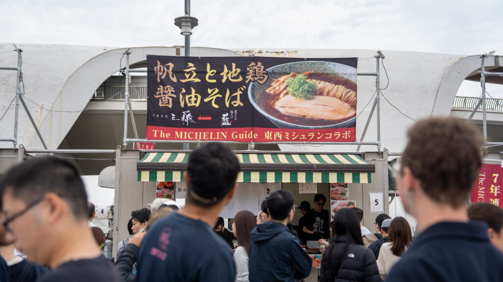 Visitors look toward a Michelin Guide collaboration ramen booth at Tokyo Ramen Festa.
