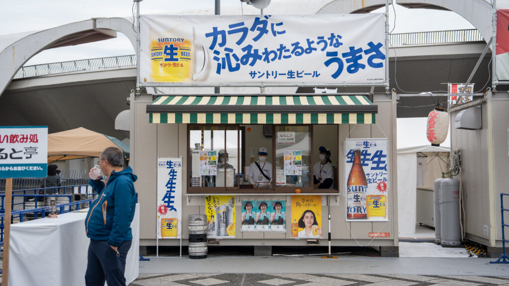 Suntory beverage booth serving draft beer and drinks during Tokyo Ramen Festa.