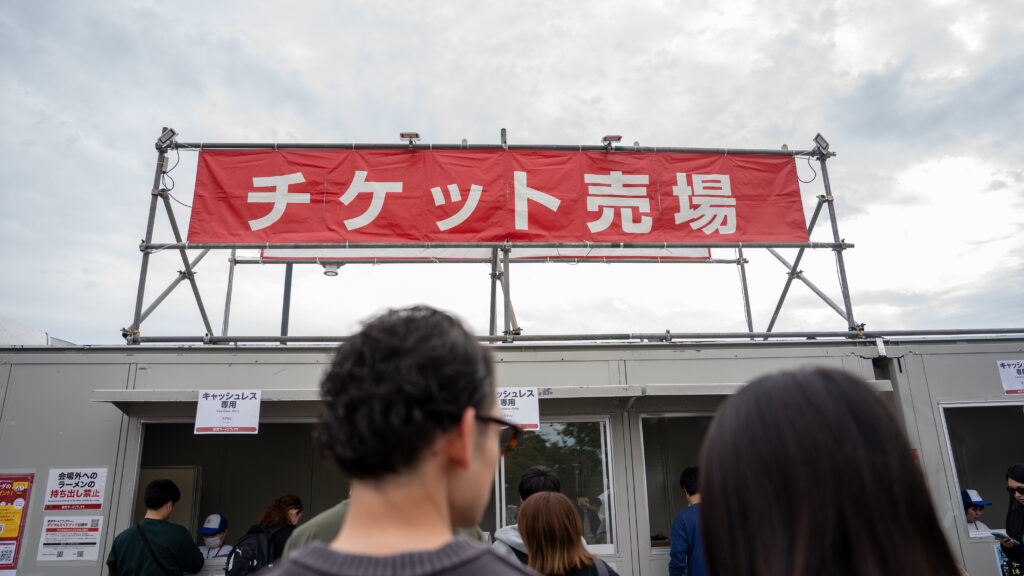 Large red ticket office sign with Japanese characters at Tokyo Ramen Festa.