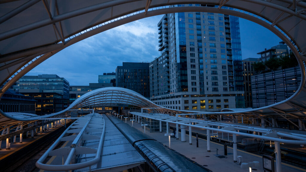 Decorative curved architectural canopy framing a partial view of downtown Denver.