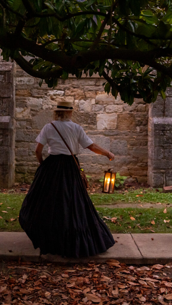 Janet Hughes carries a lantern and looks back toward guests while leading a historical ghost walk through Shepherdstown.