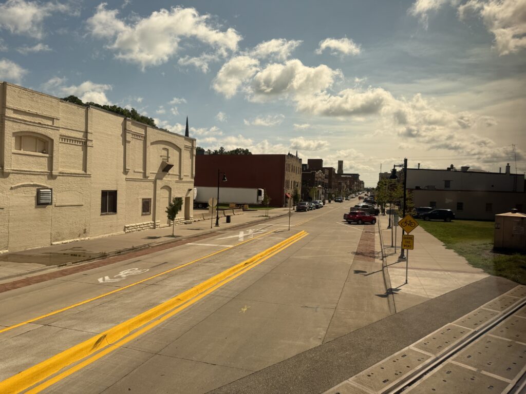 Western town with wide streets and blue sky, seen from the train.