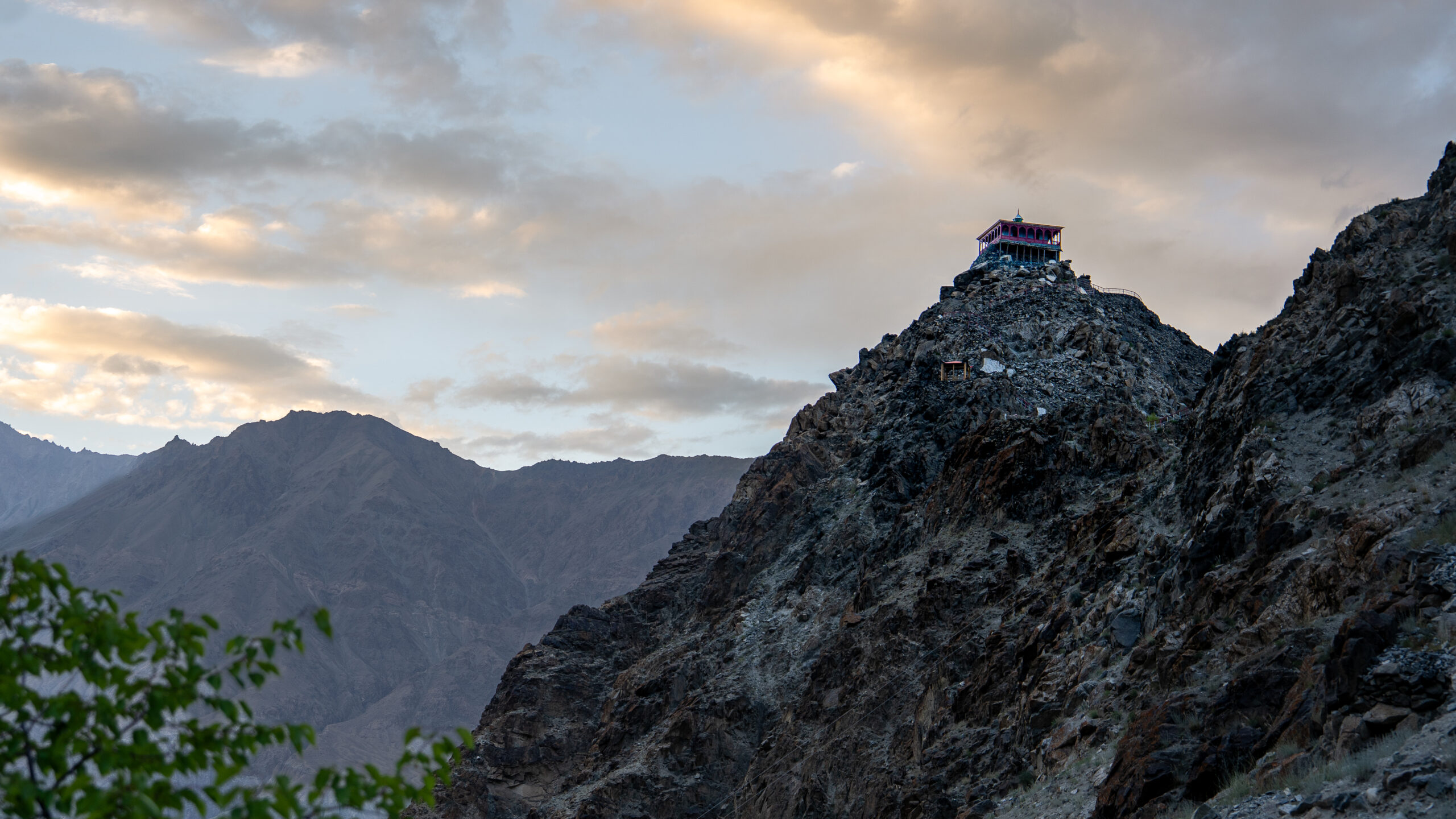 view from ground level of tall rock with fort on top